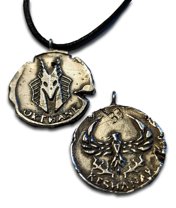 two handmade sterling silver pendants that say orthane, keshanar, with one on necklace